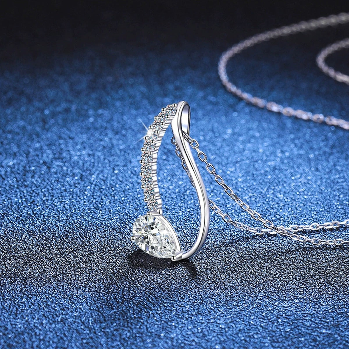 Pear-Cut Moissanite Drop Necklace in Platinum-Plated S925 Sterling Silver blue background close-up view