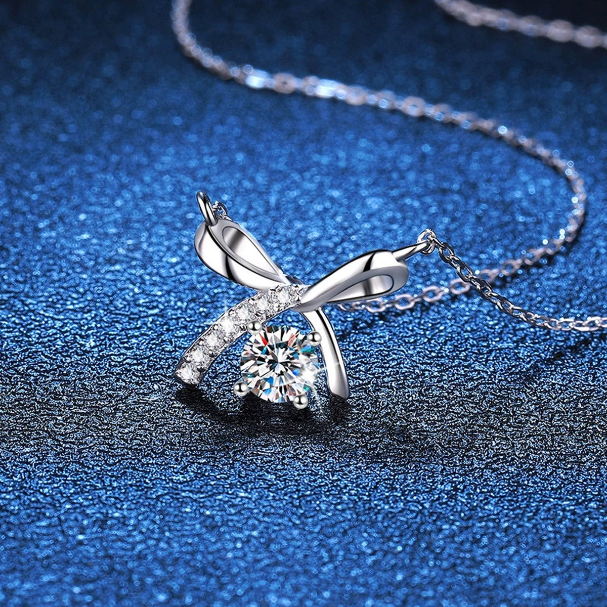 Bow Moissanite Pendant Necklace in Platinum-Plated S925 Sterling Silver blue background close-up view