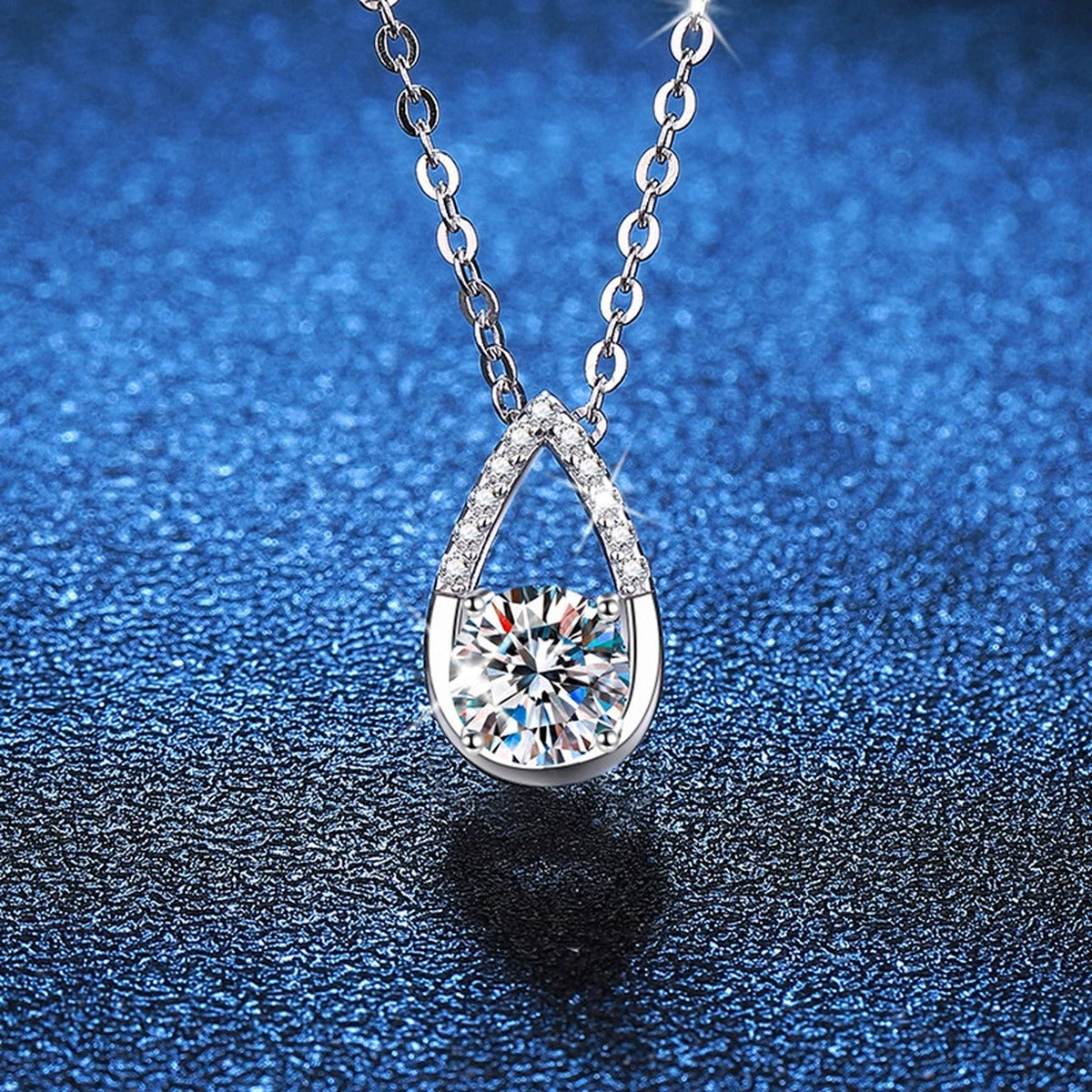 Teardrop Moissanite Pendant Necklace in Platinum-Plated S925 Sterling Silver blue background angled view