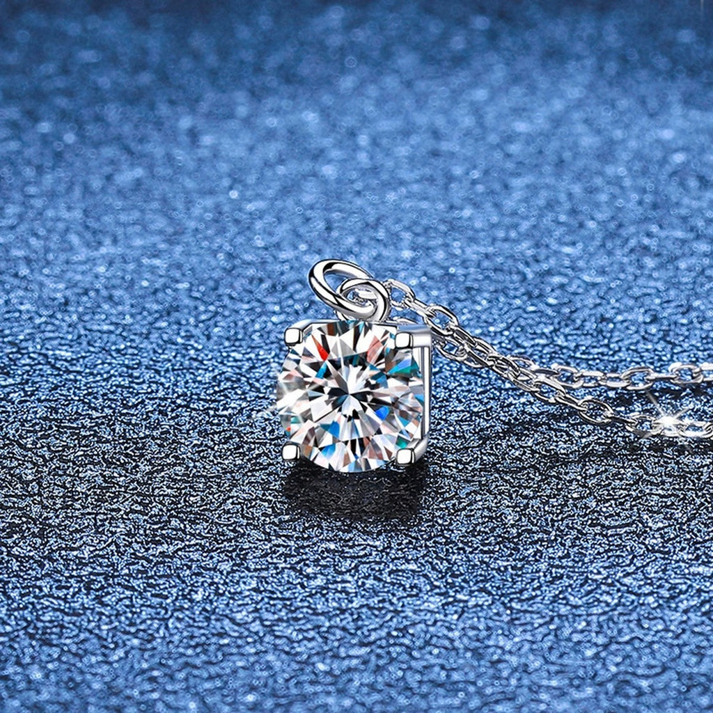 Round Solitaire Moissanite Pendant Necklace in Platinum-Plated S925 Sterling Silver blue background angled view
