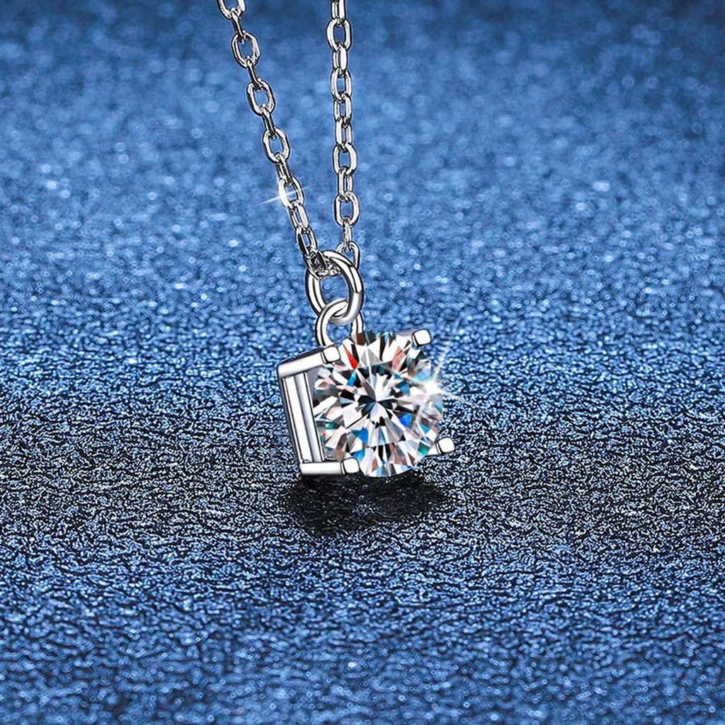 Round Solitaire Moissanite Pendant Necklace in Platinum-Plated S925 Sterling Silver blue background close-up view