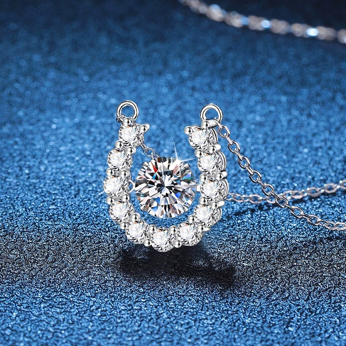 Horseshoe Halo Moissanite Pendant Necklace in Platinum-Plated S925 Sterling Silver blue background angled view