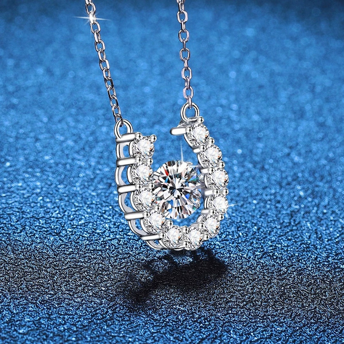 Horseshoe Halo Moissanite Pendant Necklace in Platinum-Plated S925 Sterling Silver blue background close-up view