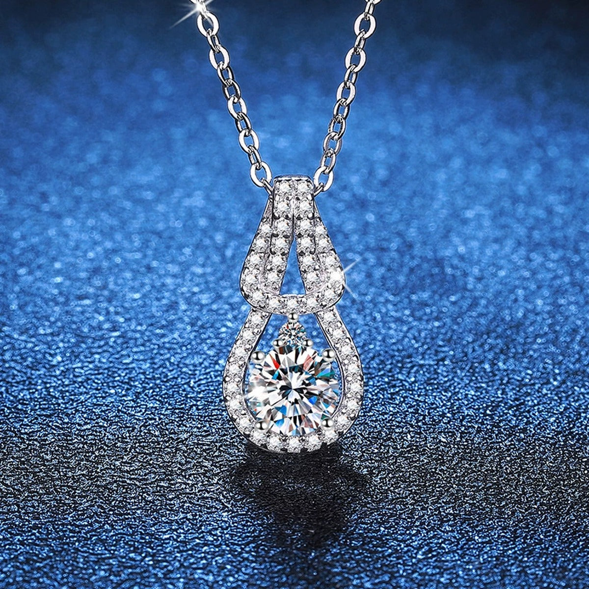 Pave Teardrop Moissanite Pendant Necklace in Platinum-Plated S925 Sterling Silver blue background close-up view