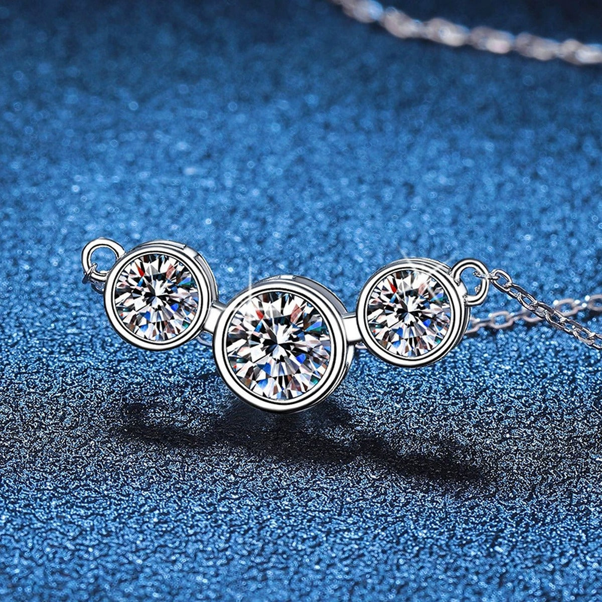 Three-Stone Moissanite Station Necklace in Platinum-Plated S925 Sterling Silver blue background angled view