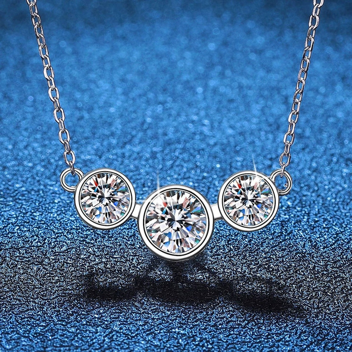 Three-Stone Moissanite Station Necklace in Platinum-Plated S925 Sterling Silver blue background close-up view
