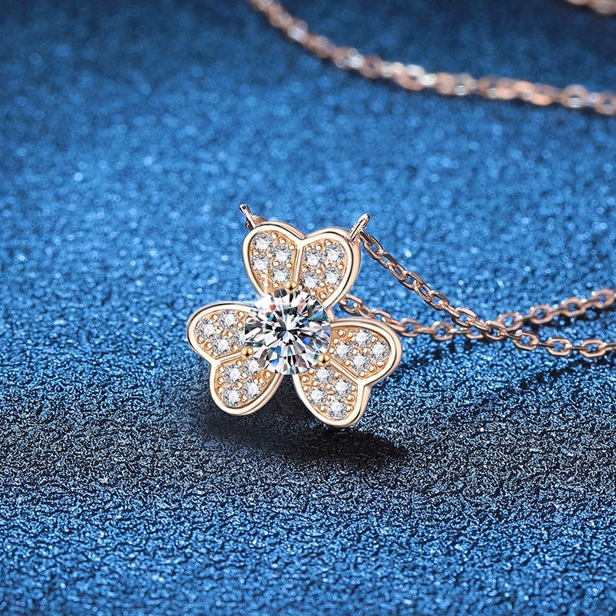 Four-Leaf Clover Moissanite Pendant Necklace in Champagne Gold-Plated S925 Sterling Silver blue background close-up view