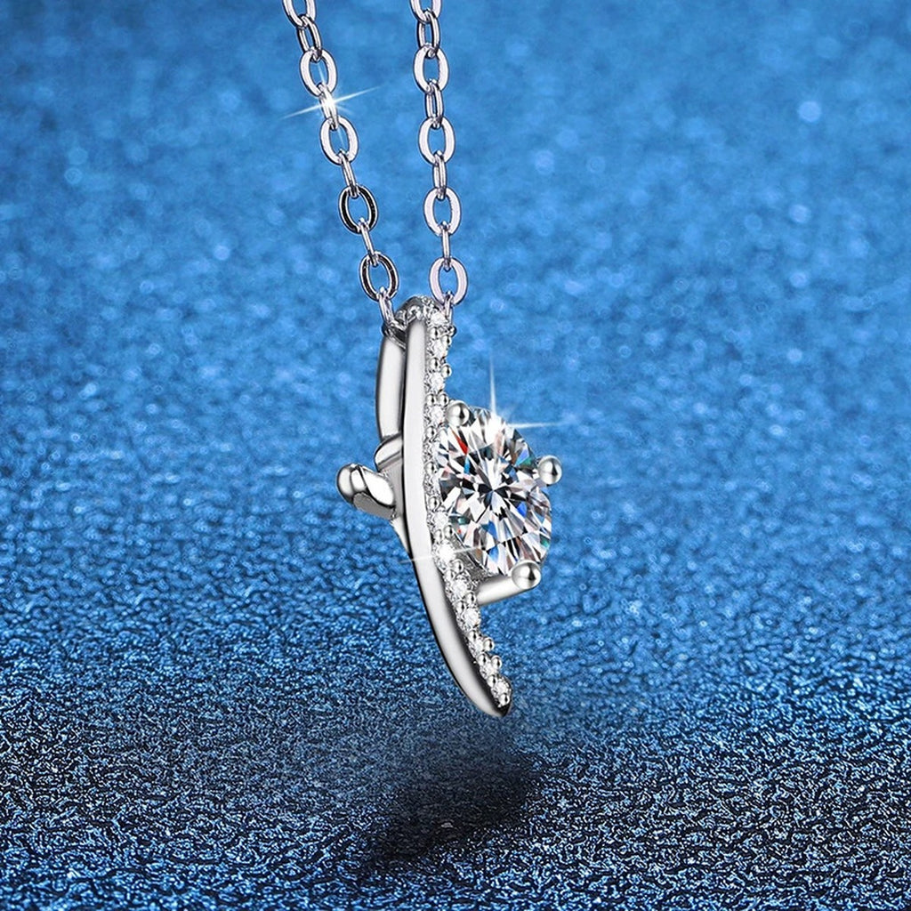 Crescent Moon Moissanite Pendant Necklace in Platinum-Plated S925 Sterling Silver blue background angled view
