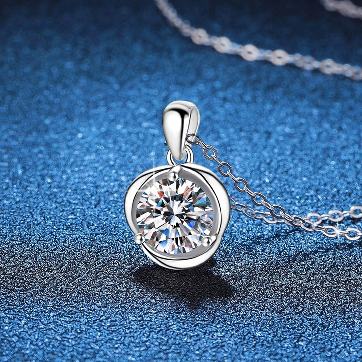 Round Bezel Moissanite Pendant Necklace in Platinum-Plated S925 Sterling Silver blue background angled view