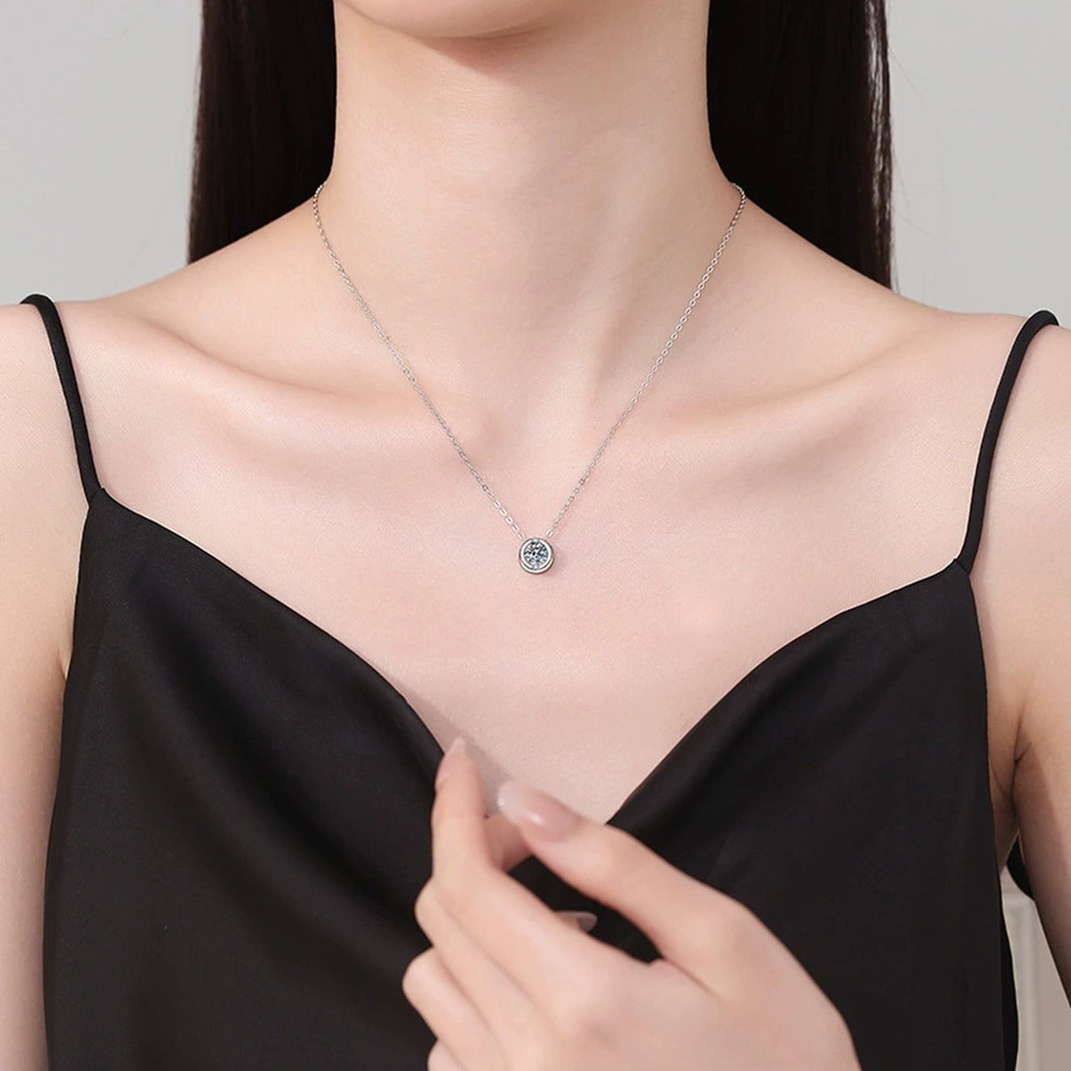 Round Solitaire Moissanite Pendant Necklace in Platinum-Plated S925 Sterling Silver worn on neckline by model