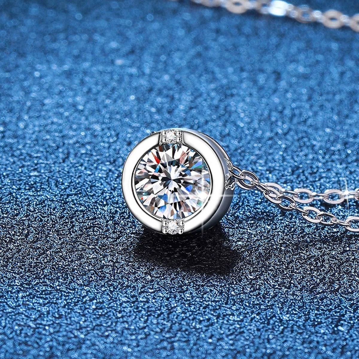 Round Solitaire Moissanite Pendant Necklace in Platinum-Plated S925 Sterling Silver blue background angled view