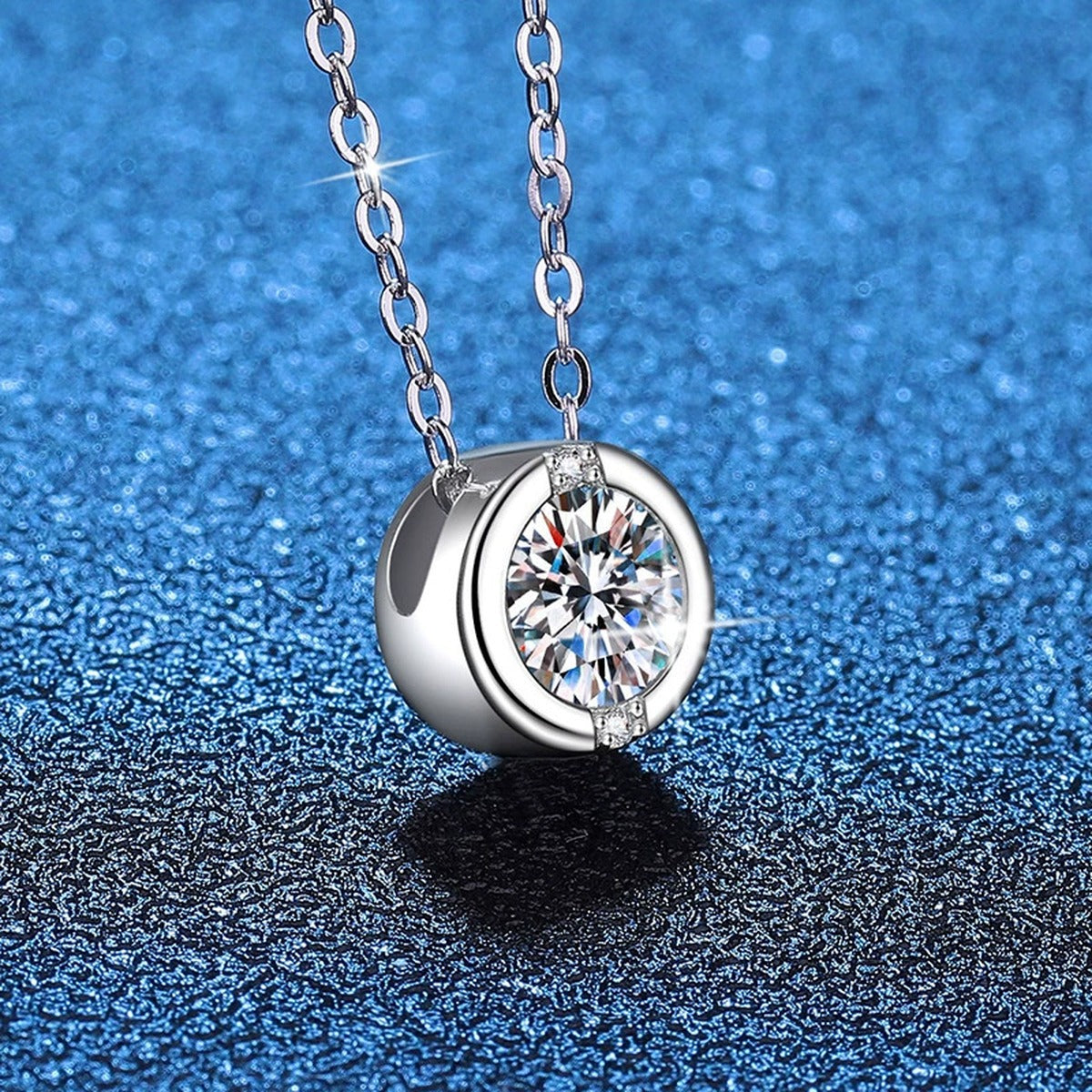 Round Solitaire Moissanite Pendant Necklace in Platinum-Plated S925 Sterling Silver blue background close-up view