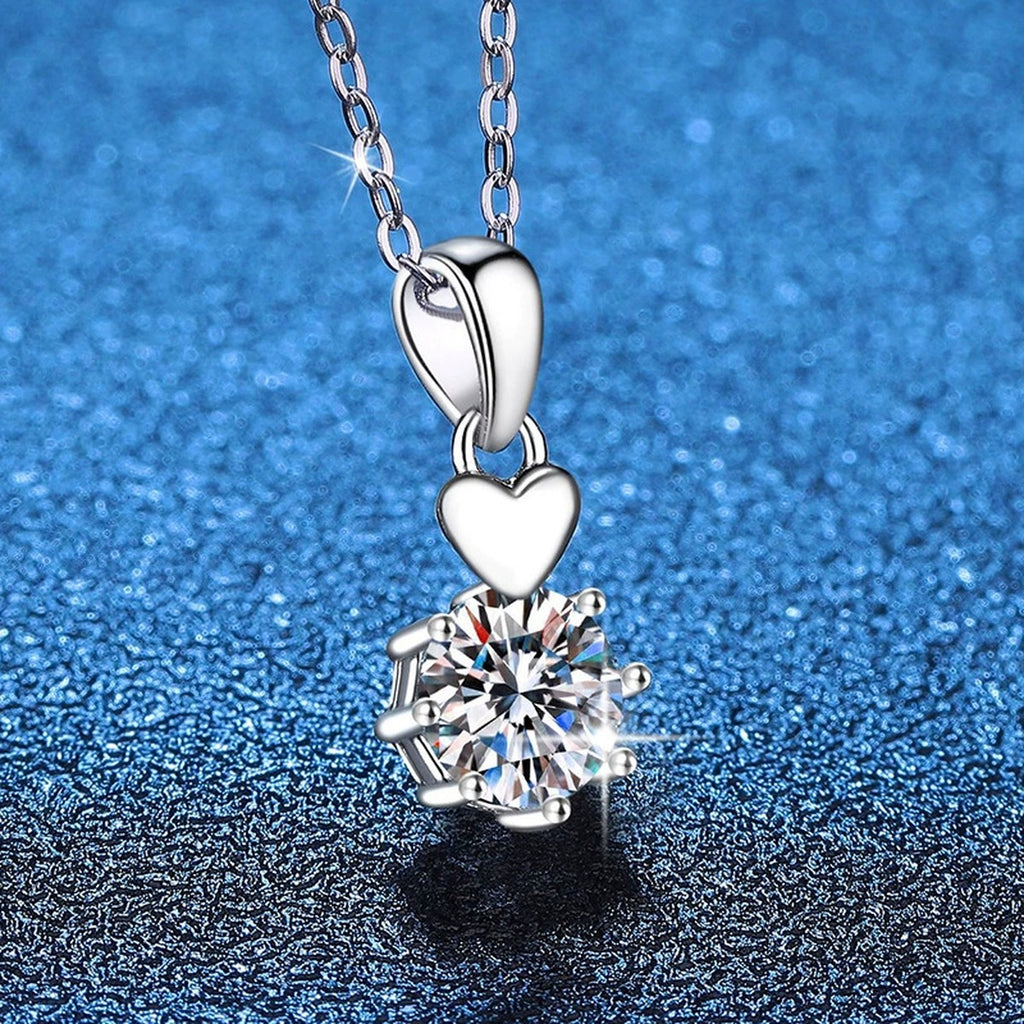 Heart Charm Moissanite Pendant Necklace in Platinum-Plated S925 Sterling Silver blue background close-up view