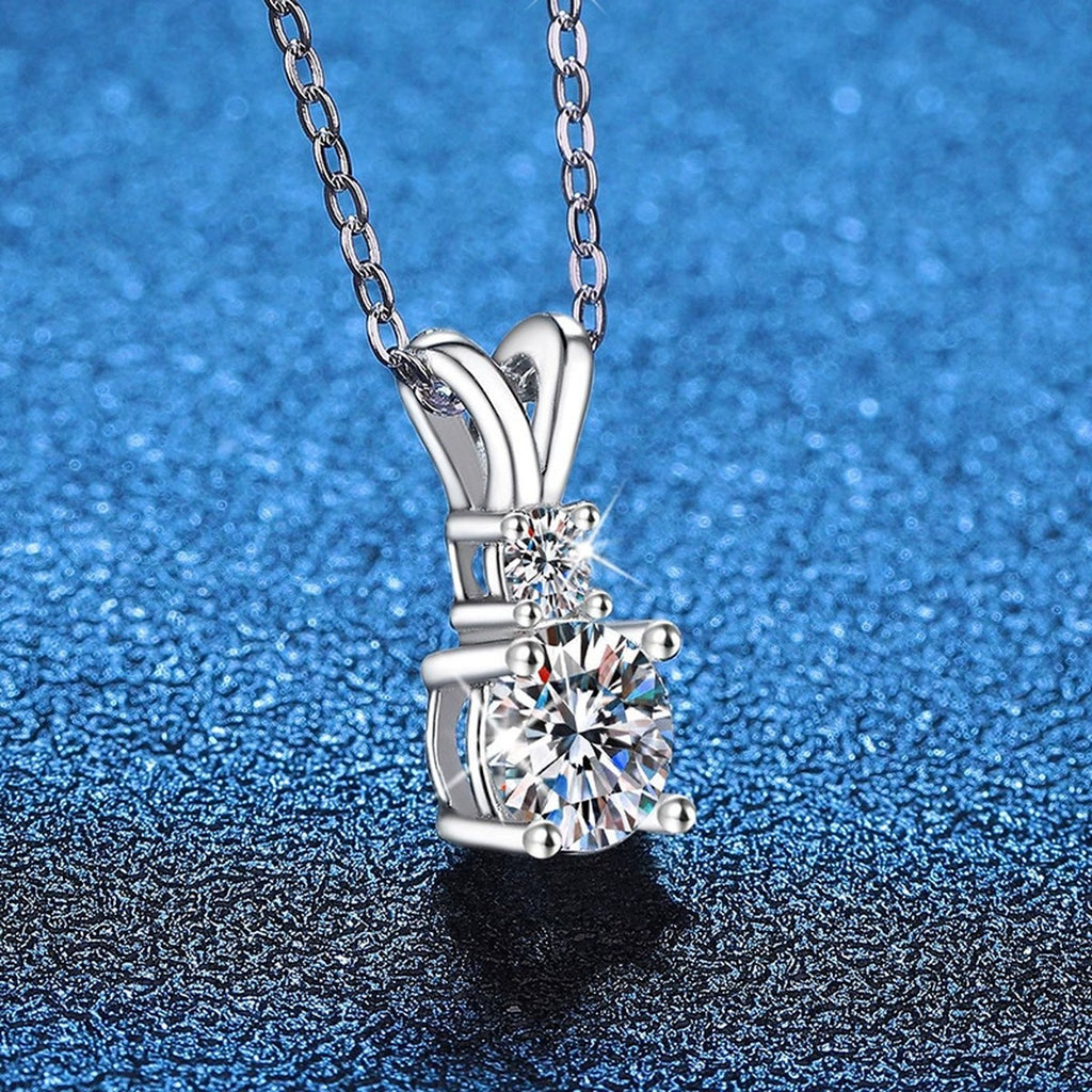 Graduated Drop Moissanite Pendant Necklace in Platinum-Plated S925 Sterling Silver blue background angled view