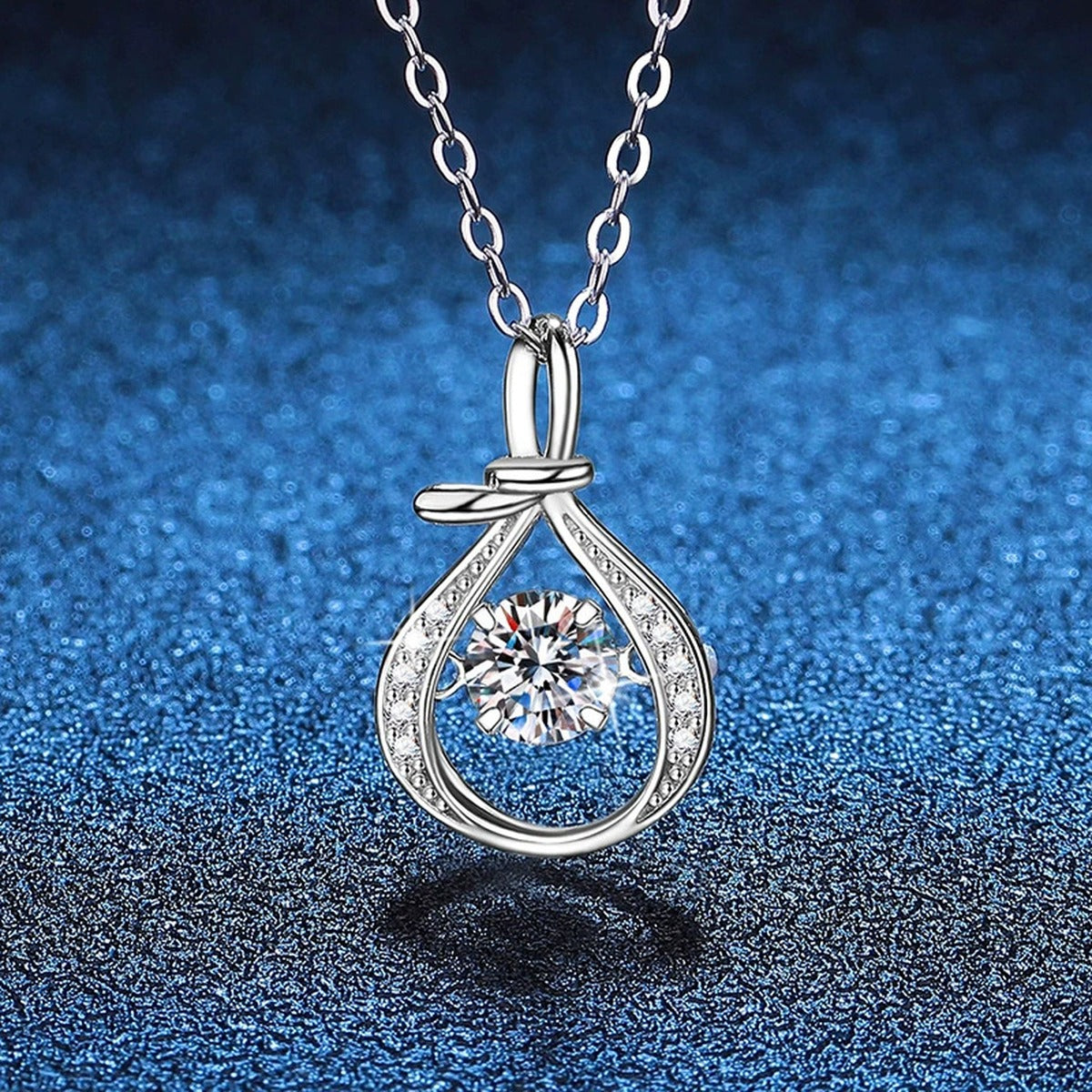 Teardrop Halo Moissanite Pendant Necklace in Platinum-Plated S925 Sterling Silver blue background angled view