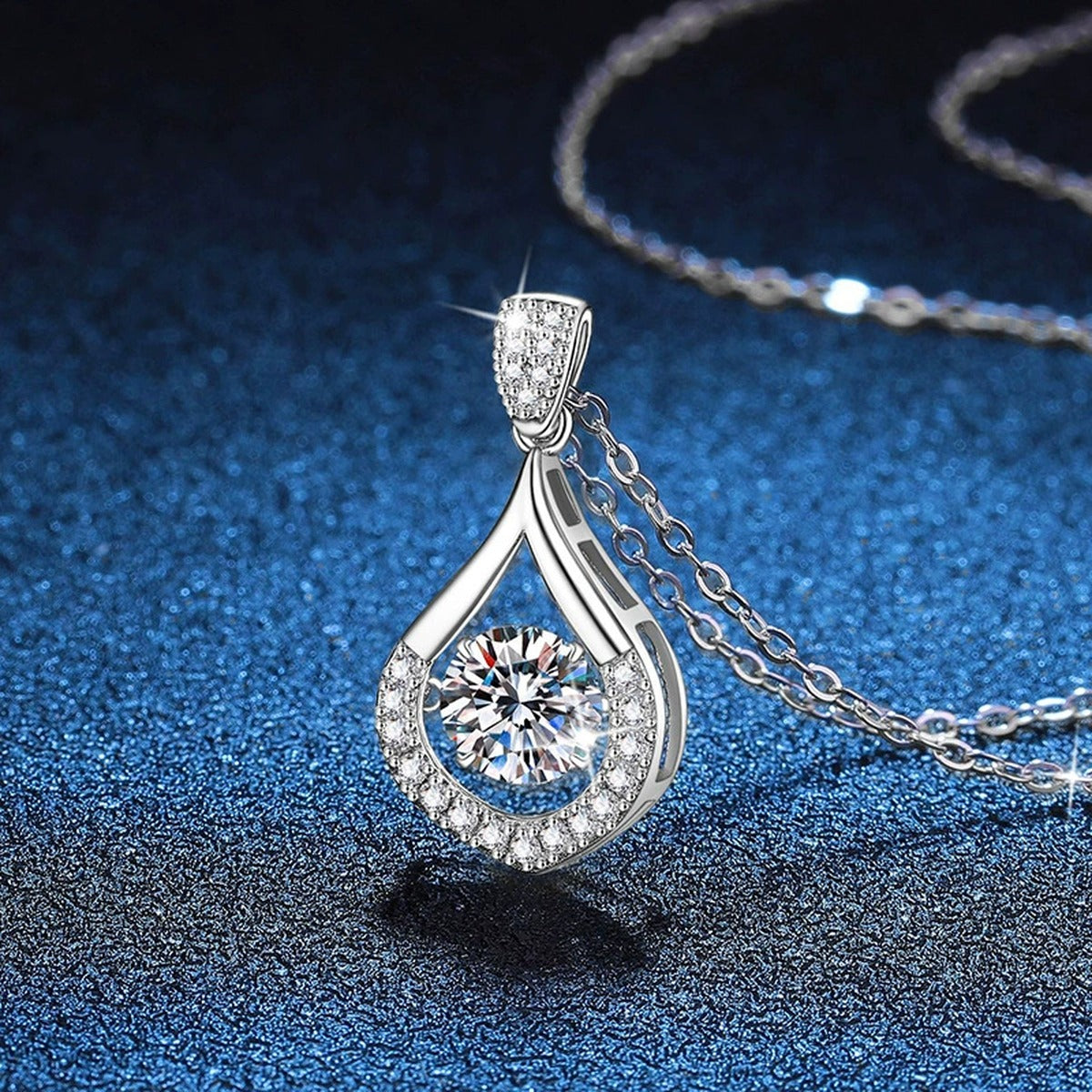 Teardrop Halo Moissanite Pendant Necklace in Platinum-Plated S925 Sterling Silver blue background angled view