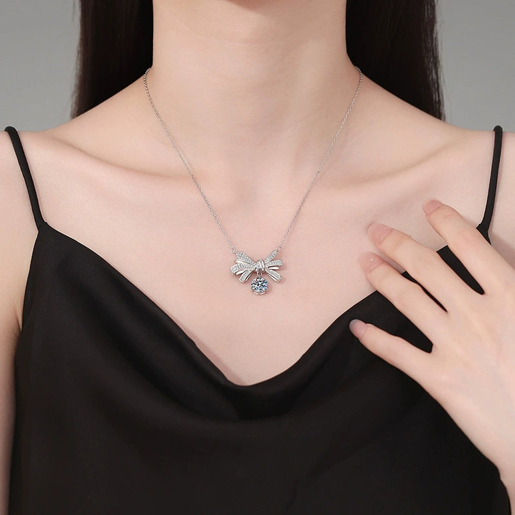 Bow Drop Moissanite Pendant Necklace in Platinum-Plated S925 Sterling Silver worn on neckline by model