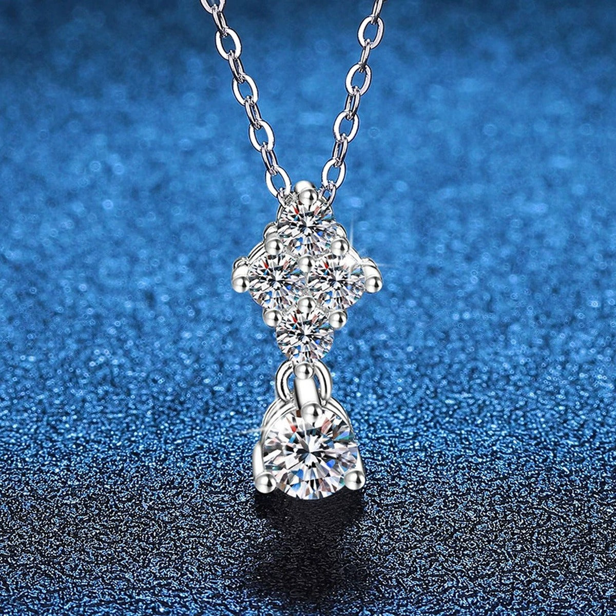 Graduated Cluster Moissanite Drop Necklace in Platinum-Plated S925 Sterling Silver blue background angled view