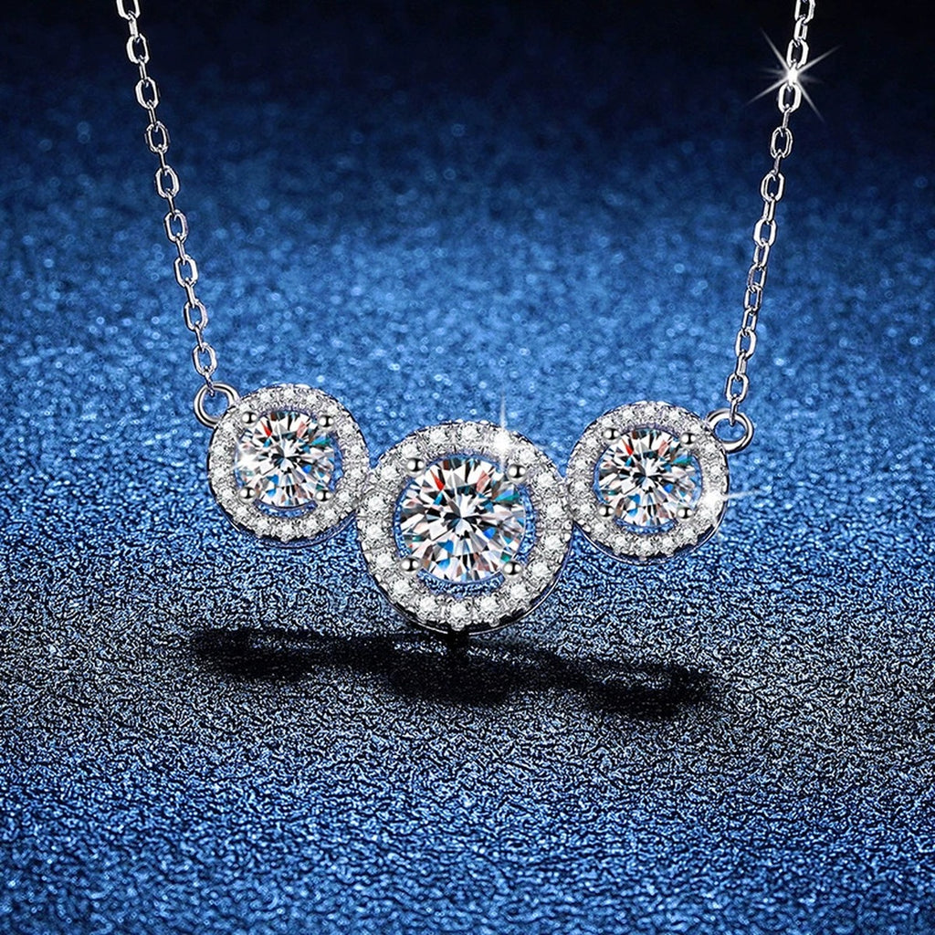Three-Stone Halo Moissanite Station Necklace in Platinum-Plated S925 Sterling Silver blue background angled view
