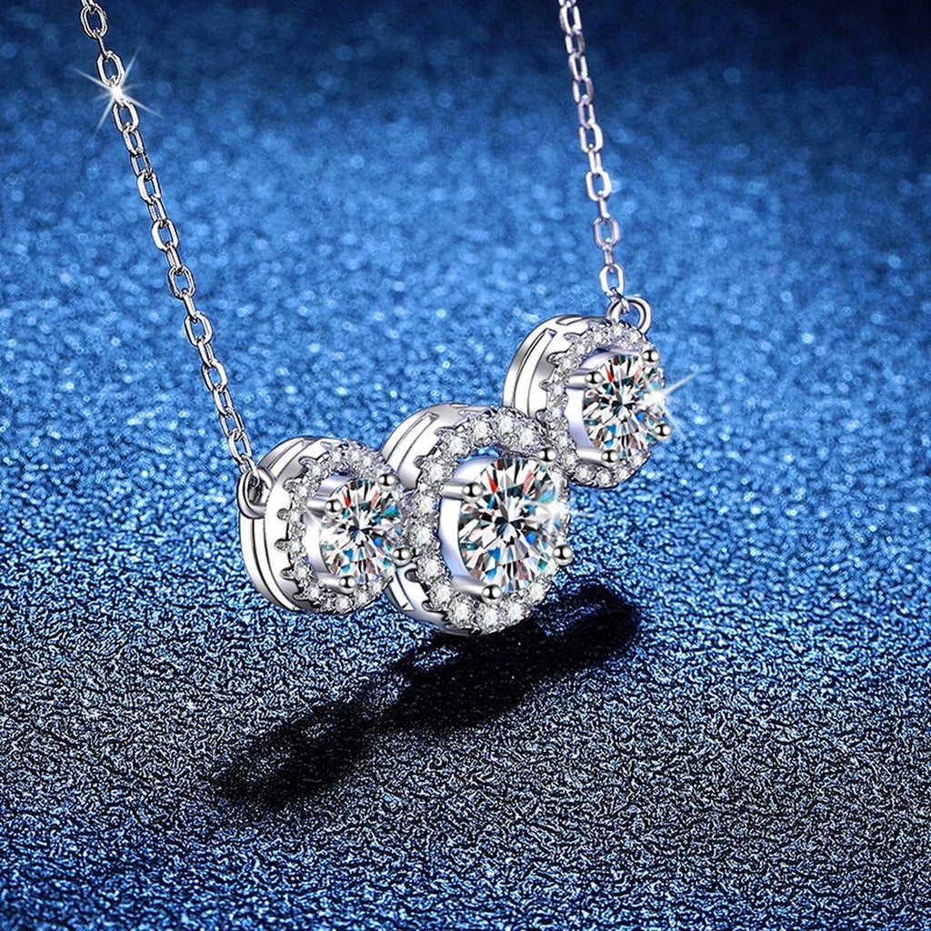 Three-Stone Halo Moissanite Station Necklace in Platinum-Plated S925 Sterling Silver blue background close-up view