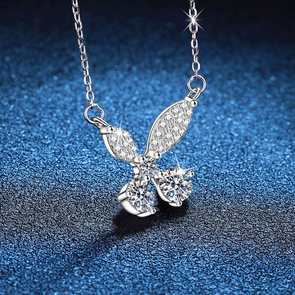 Butterfly Bow Moissanite Pendant Necklace in Platinum-Plated S925 Sterling Silver blue background angled view