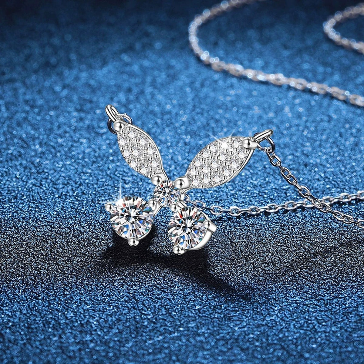 Butterfly Bow Moissanite Pendant Necklace in Platinum-Plated S925 Sterling Silver blue background close-up view