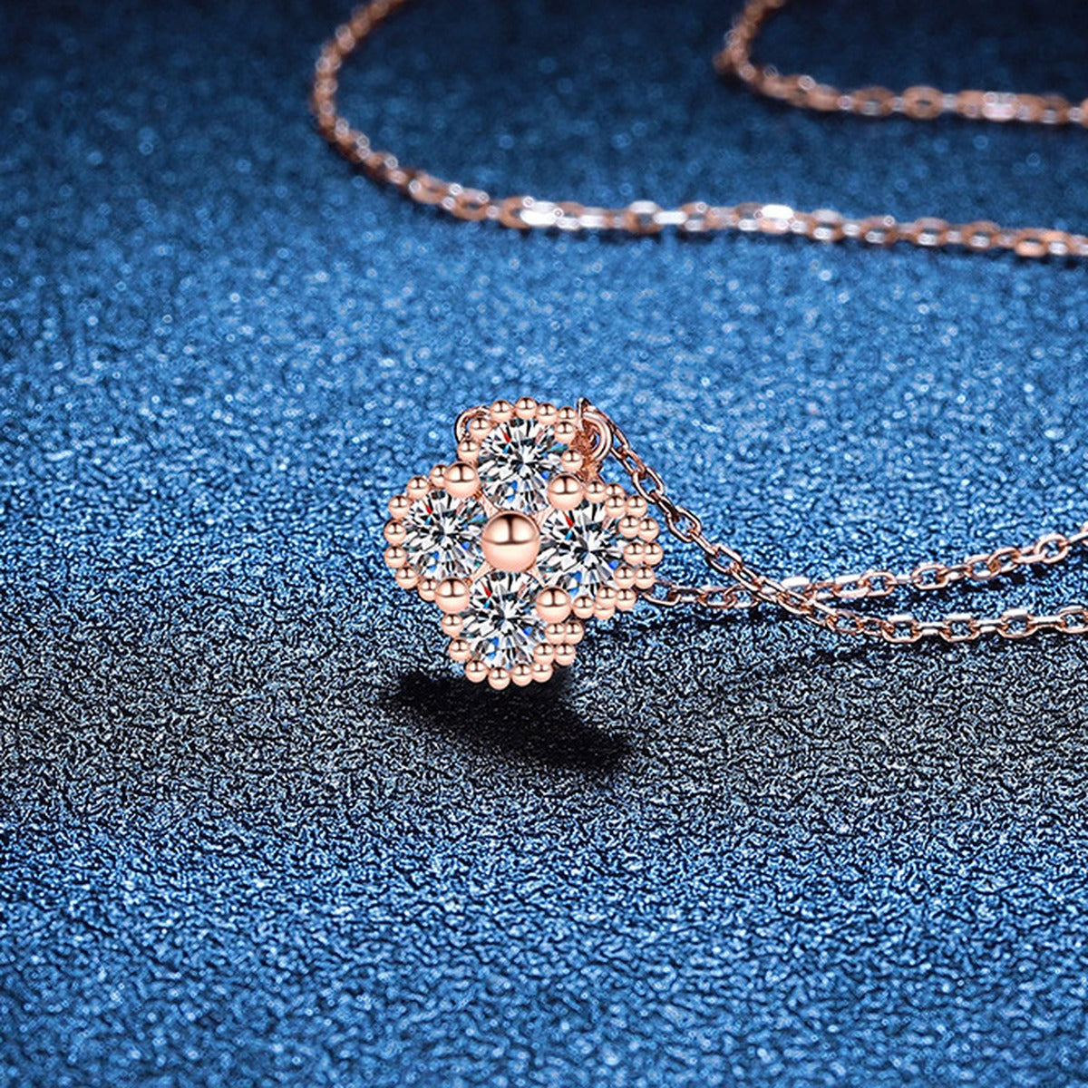 Four-Stone Clover Moissanite Pendant Necklace in S925 Sterling Silver blue background angled view