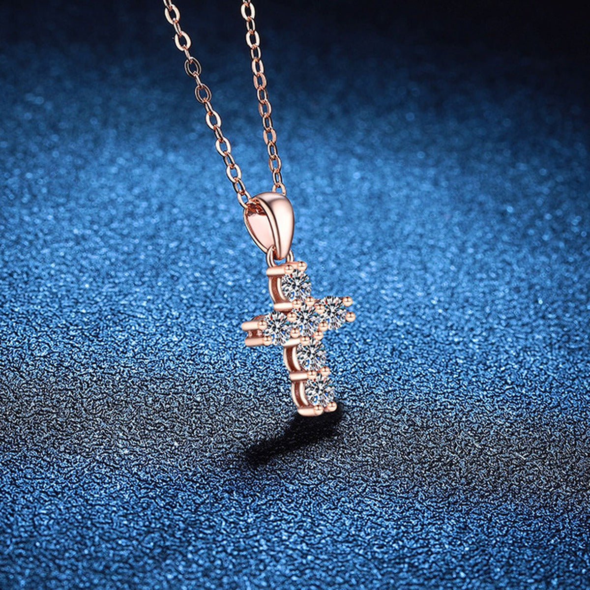 Cross Moissanite Pendant Necklace in S925 Sterling Silver blue background angled view