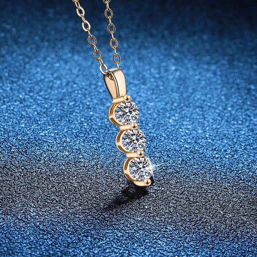 Vertical Three-Stone Moissanite Drop Necklace in S925 Sterling Silver blue background angled view