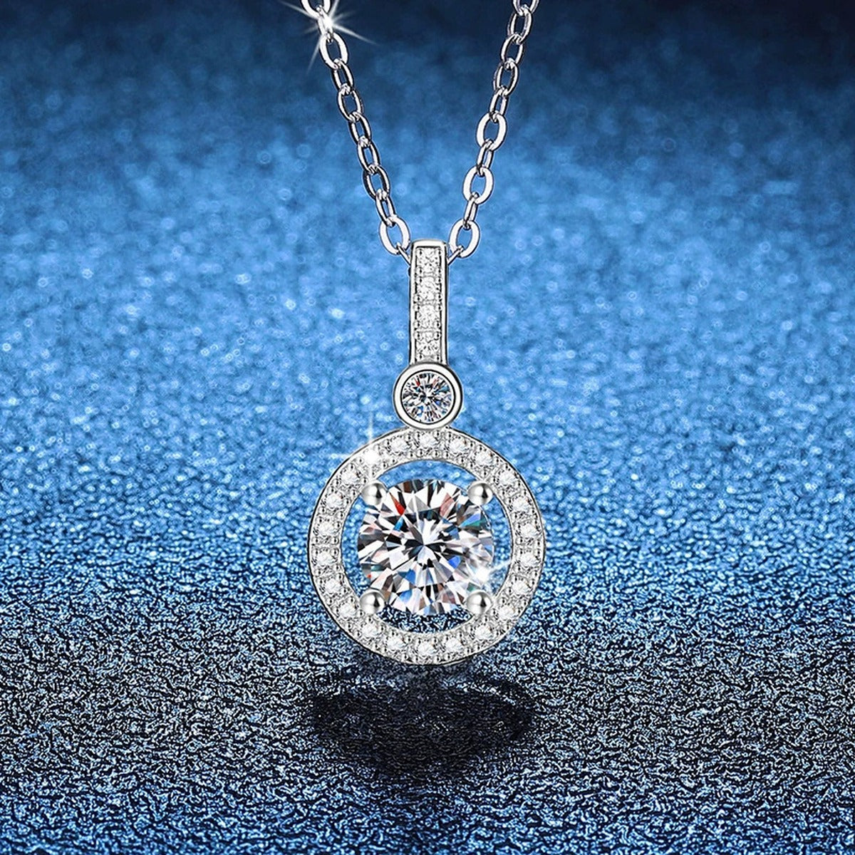Round Halo Drop Moissanite Pendant Necklace in Platinum-Plated S925 Sterling Silver blue background angled view