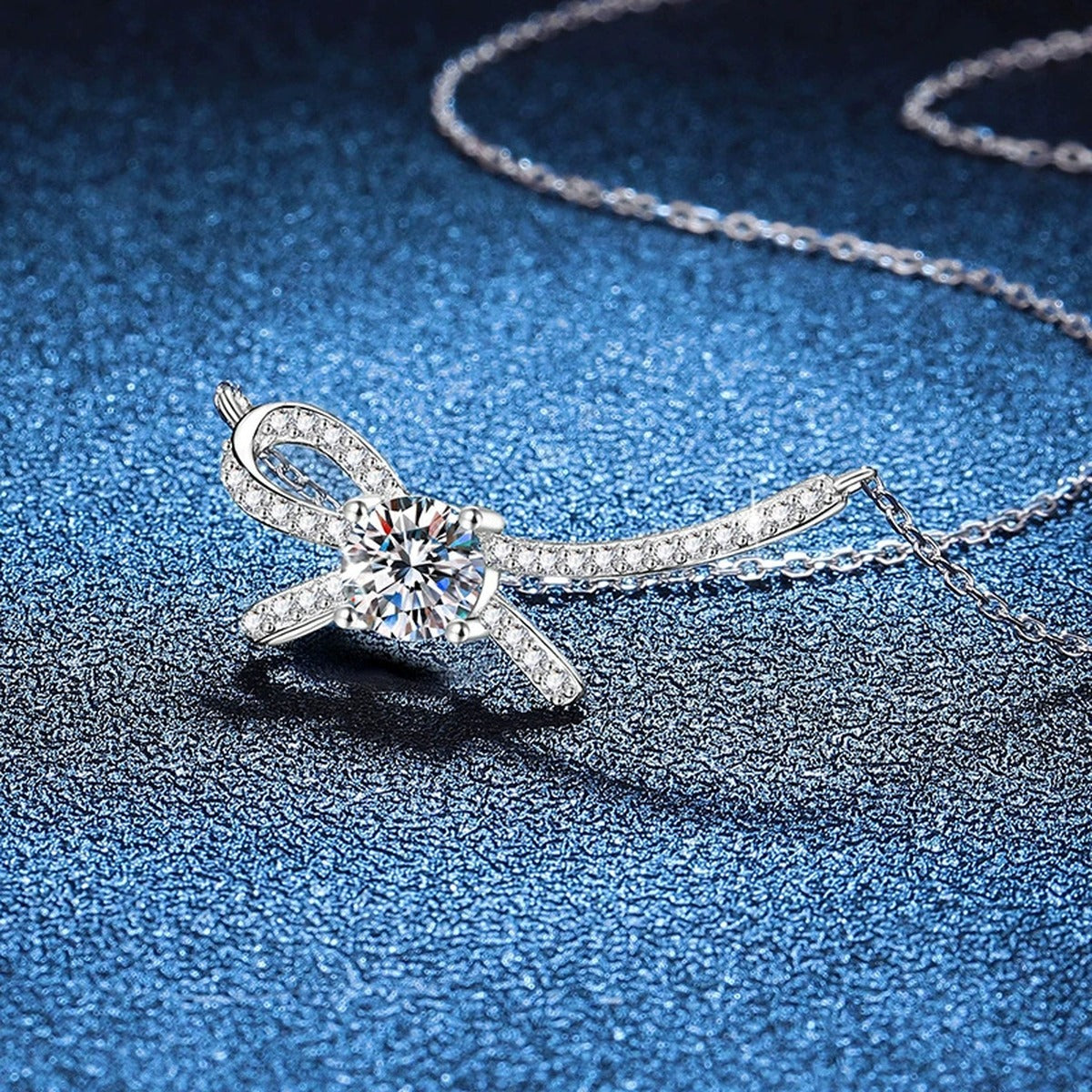 Ribbon Bow Moissanite Collar Necklace in Platinum-Plated S925 Sterling Silver blue background angled view
