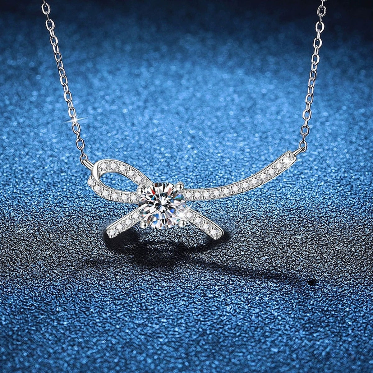 Ribbon Bow Moissanite Collar Necklace in Platinum-Plated S925 Sterling Silver blue background close-up view