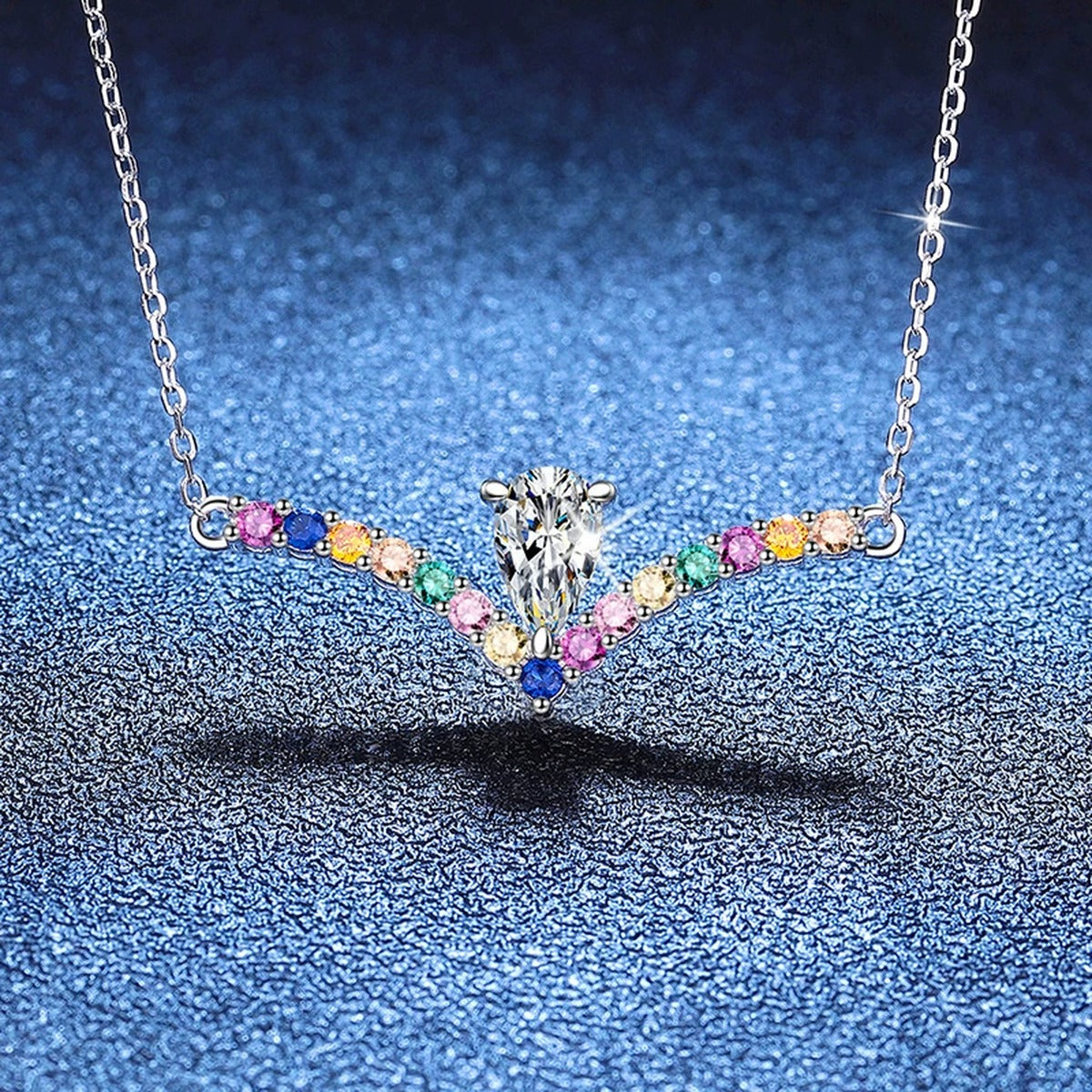 Rainbow Pear-Cut Moissanite Collar Necklace in Platinum-Plated S925 Sterling Silver blue background angled view