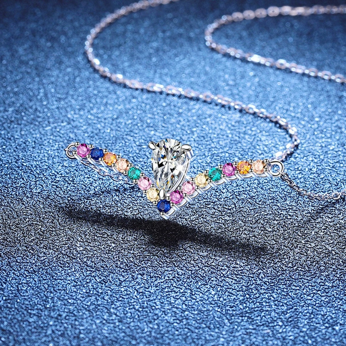 Rainbow Pear-Cut Moissanite Collar Necklace in Platinum-Plated S925 Sterling Silver blue background close-up view