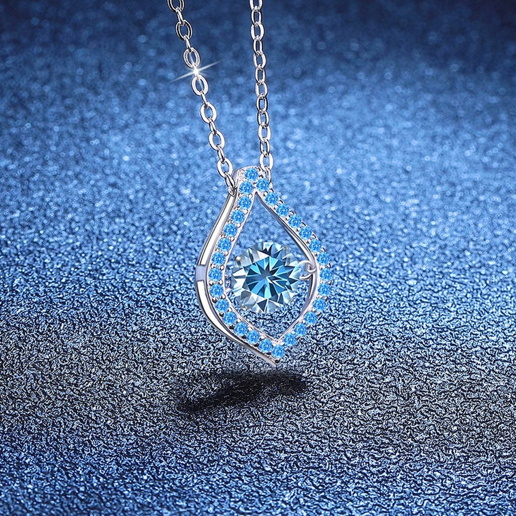 Blue Moissanite Teardrop Pendant Necklace in Platinum-Plated S925 Sterling Silver blue background angled view