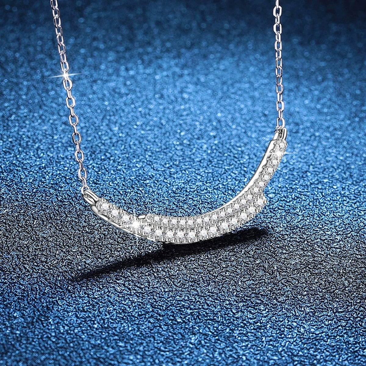 Curved Moissanite Bar Necklace in Platinum-Plated S925 Sterling Silver blue background close-up view