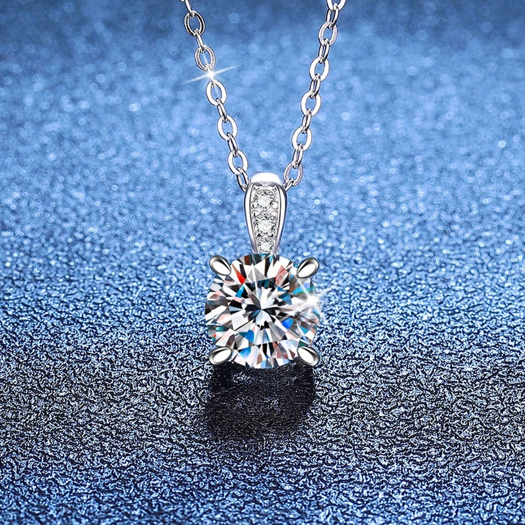 Round Moissanite Pendant Necklace with Cubic Zirconia Bail in S925 Sterling Silver blue background angled view