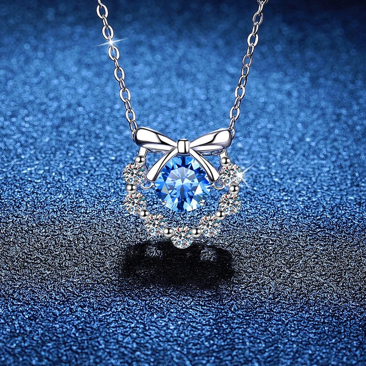 Bow Halo Moissanite Pendant Necklace with Cubic Zirconia in Platinum-Plated S925 Sterling Silver blue background close-up view