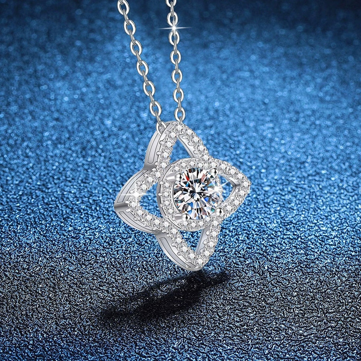 Four-Petal Halo Moissanite Pendant Necklace with Cubic Zirconia in Platinum-Plated S925 Sterling Silver blue background angled view