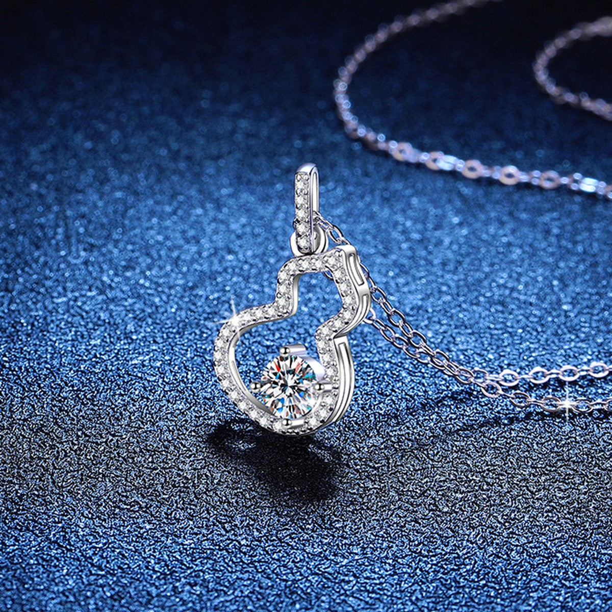 Open Heart Moissanite Pendant Necklace with Cubic Zirconia in Platinum-Plated S925 Sterling Silver blue background angled view