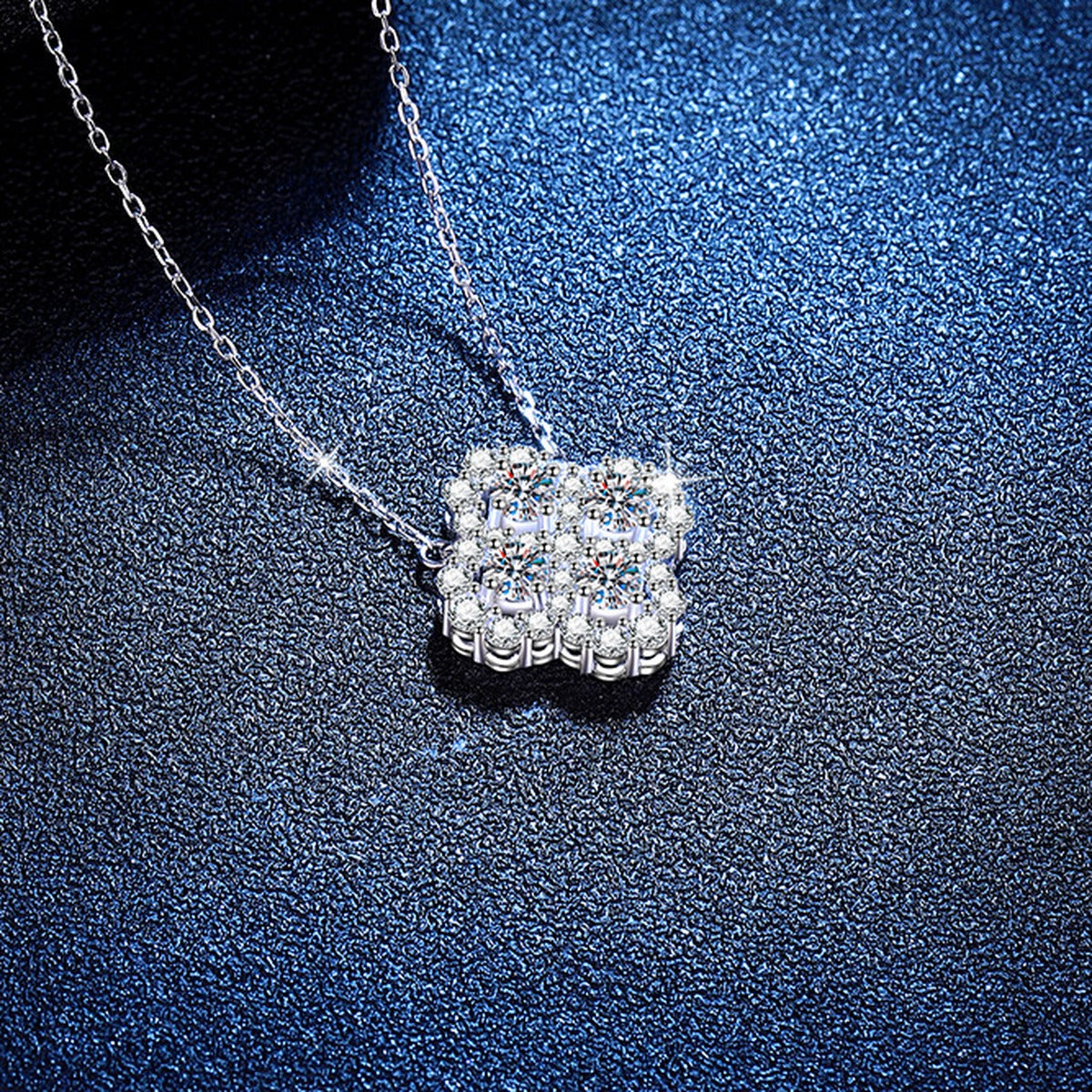 Four-Leaf Clover Moissanite Pendant Necklace with Cubic Zirconia in Platinum-Plated S925 Sterling Silver blue background angled view