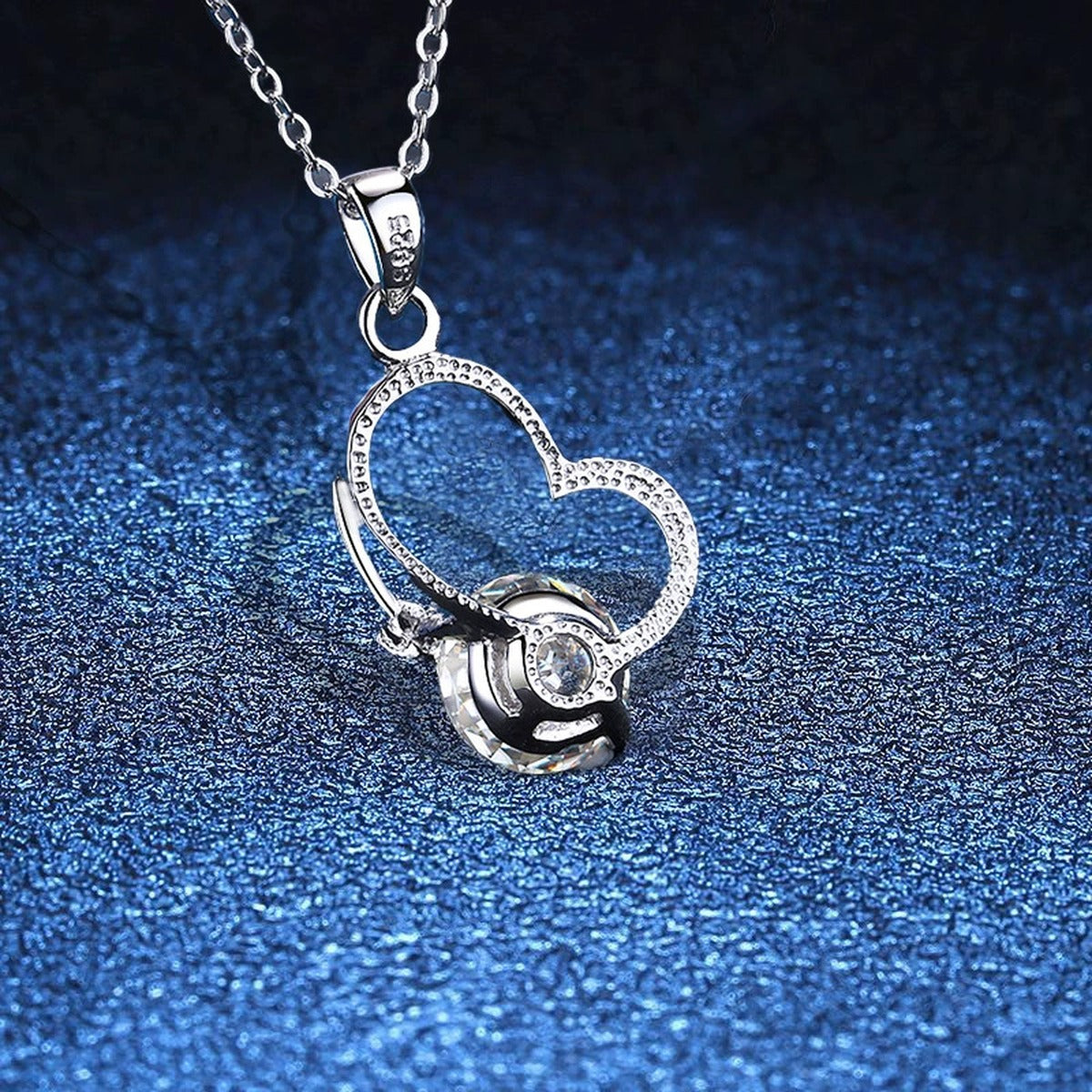 Open Heart Moissanite Pendant Necklace in Platinum-Plated S925 Sterling Silver blue background angled view