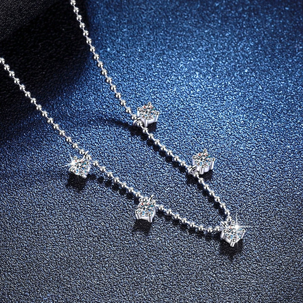 Five-Stone Station Moissanite Necklace in Platinum-Plated S925 Sterling Silver blue background angled view