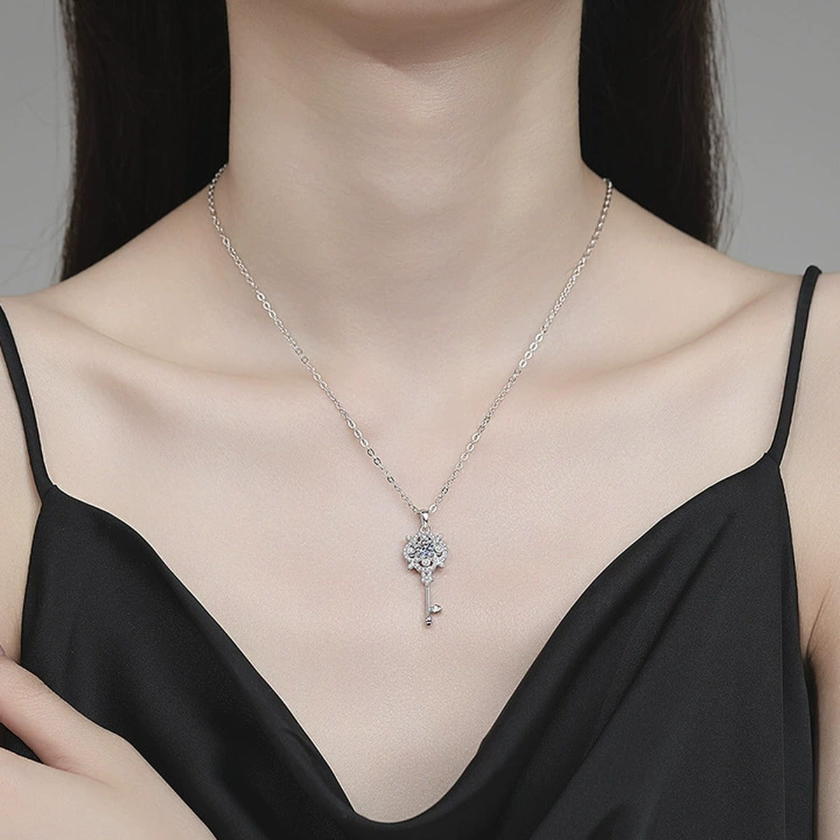 Ornate Key Moissanite Pendant Necklace with Cubic Zirconia in Platinum-Plated S925 Sterling Silver worn on neckline by model