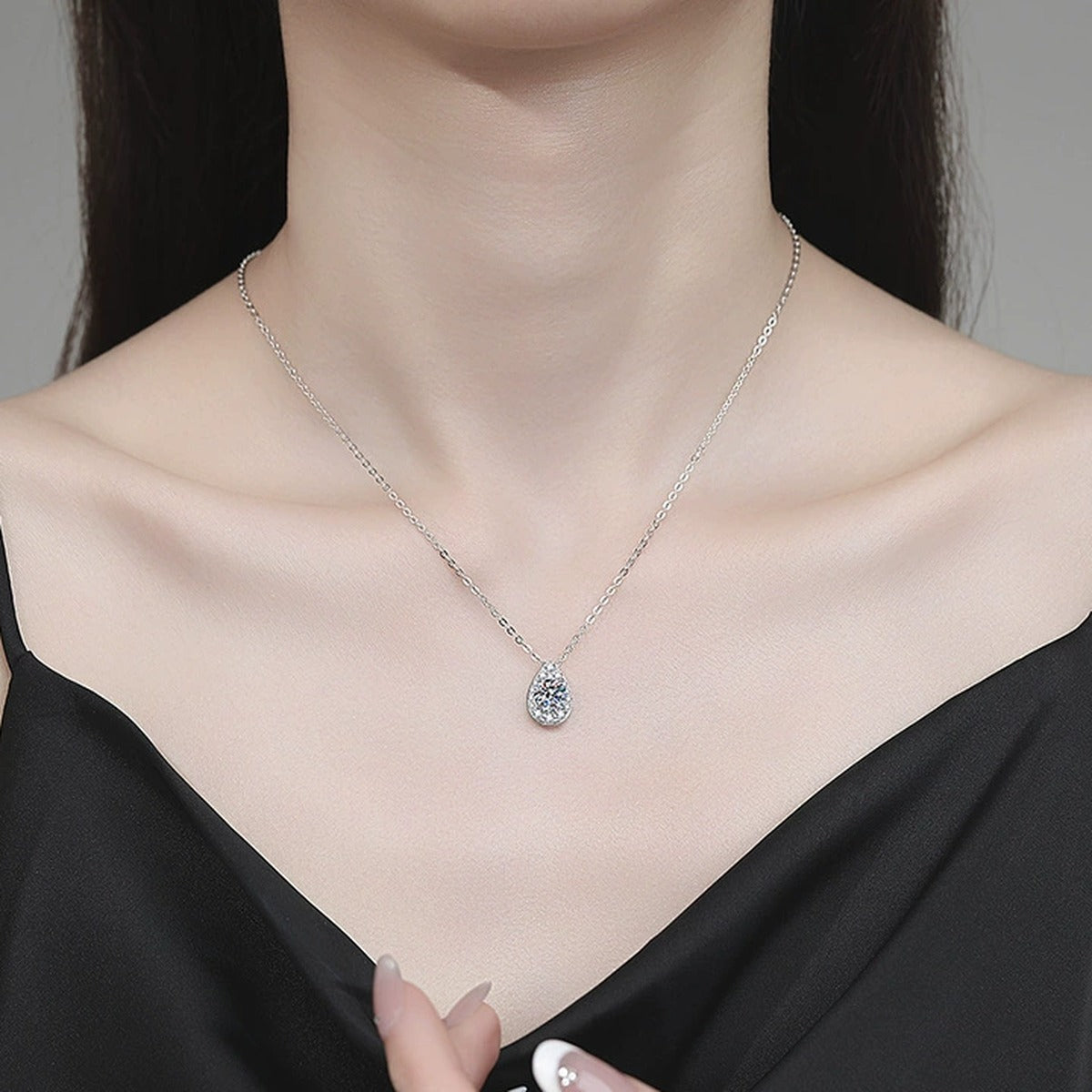 Pear Halo Moissanite Pendant Necklace with Cubic Zirconia in Platinum-Plated S925 Sterling Silver worn on neckline by model