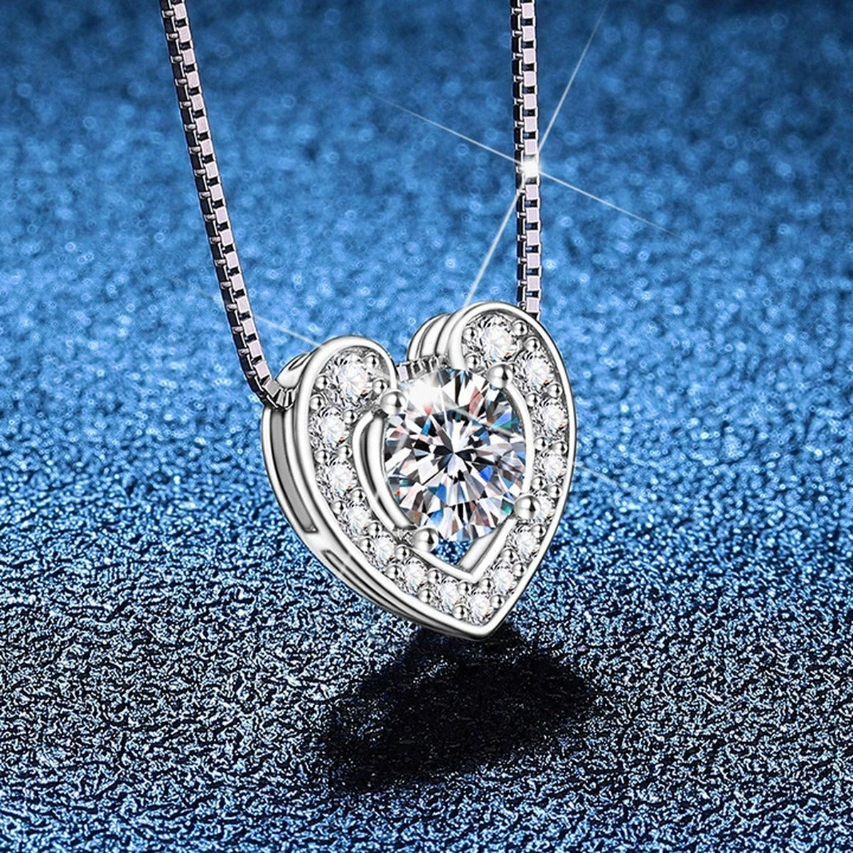 Heart Moissanite Pendant Necklace with Box Chain in Platinum-Plated S925 Sterling Silver blue background close-up view