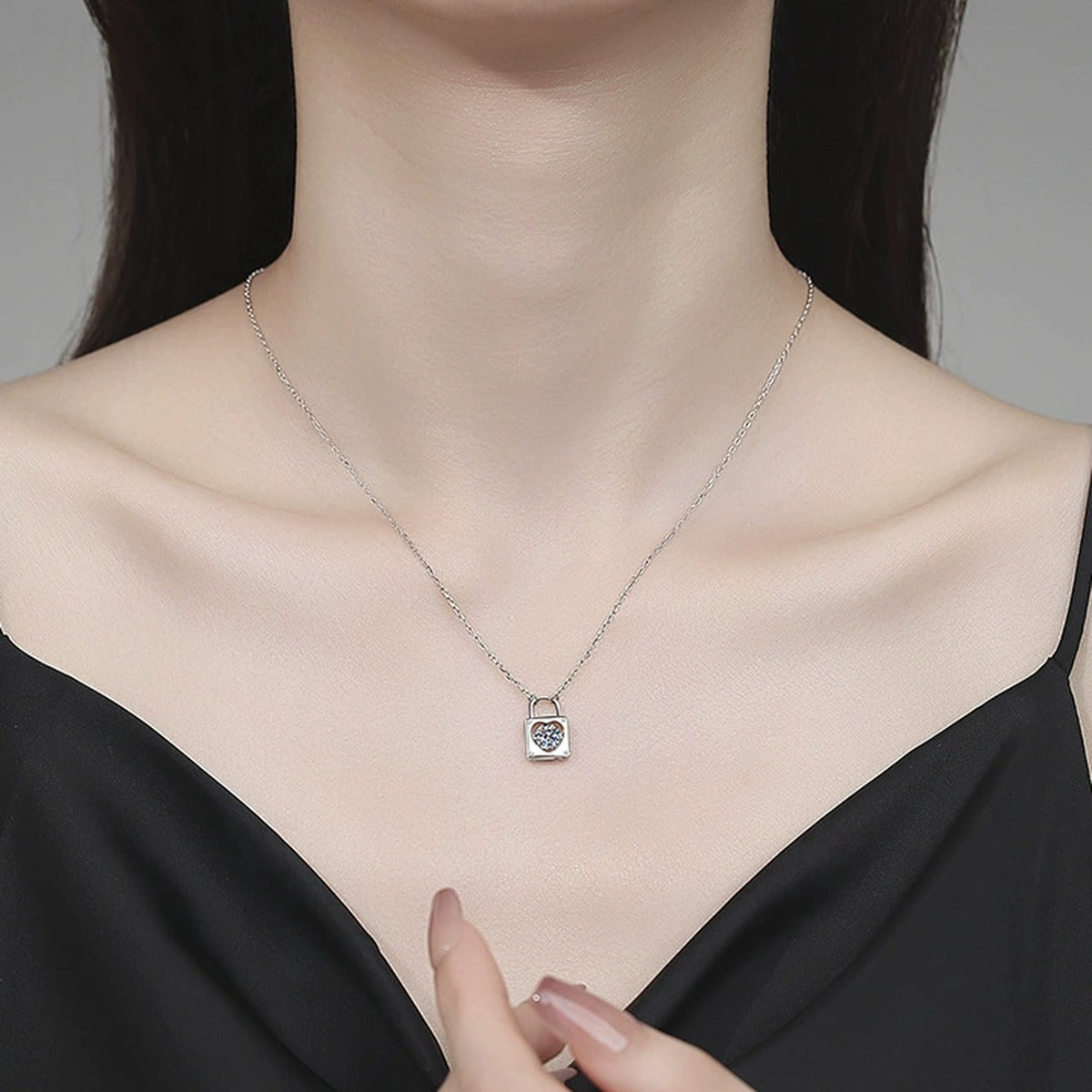 Lock Heart Moissanite Pendant Necklace with Cubic Zirconia in Platinum-Plated S925 Sterling Silver worn on neckline by model