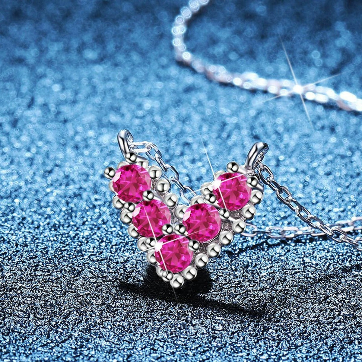 Heart Moissanite Pendant Necklace in Platinum-Plated S925 Sterling Silver blue background angled view