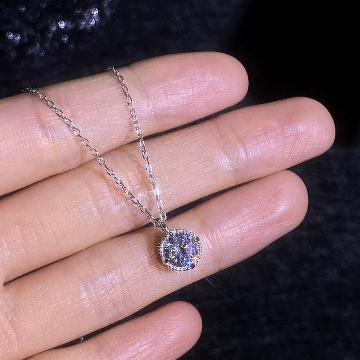 Solitaire Moissanite Pendant Necklace in Platinum-Plated S925 Sterling Silver worn on neckline by model