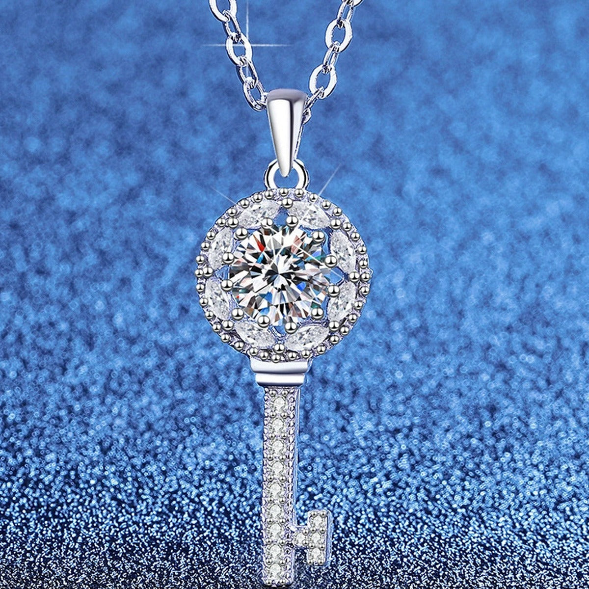 Teardrop Halo Moissanite Pendant Necklace with Cubic Zirconia in Platinum-Plated S925 Sterling Silver blue background angled view